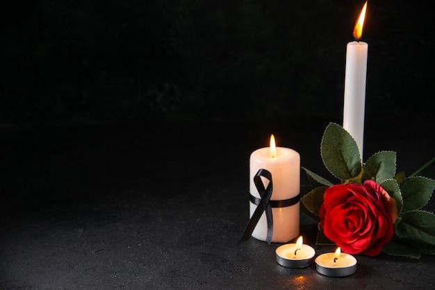 Free photo front view of burning candle with red flower on dark surface