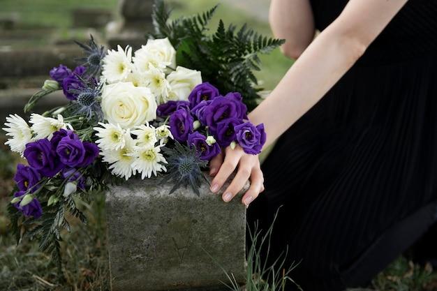 Free photo close up on woman visiting the grave of loved one